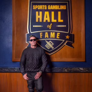 Steve Stevens of VIP Sports stands proudly next to the Hall of Fame sign, embodying the excitement of sports betting.